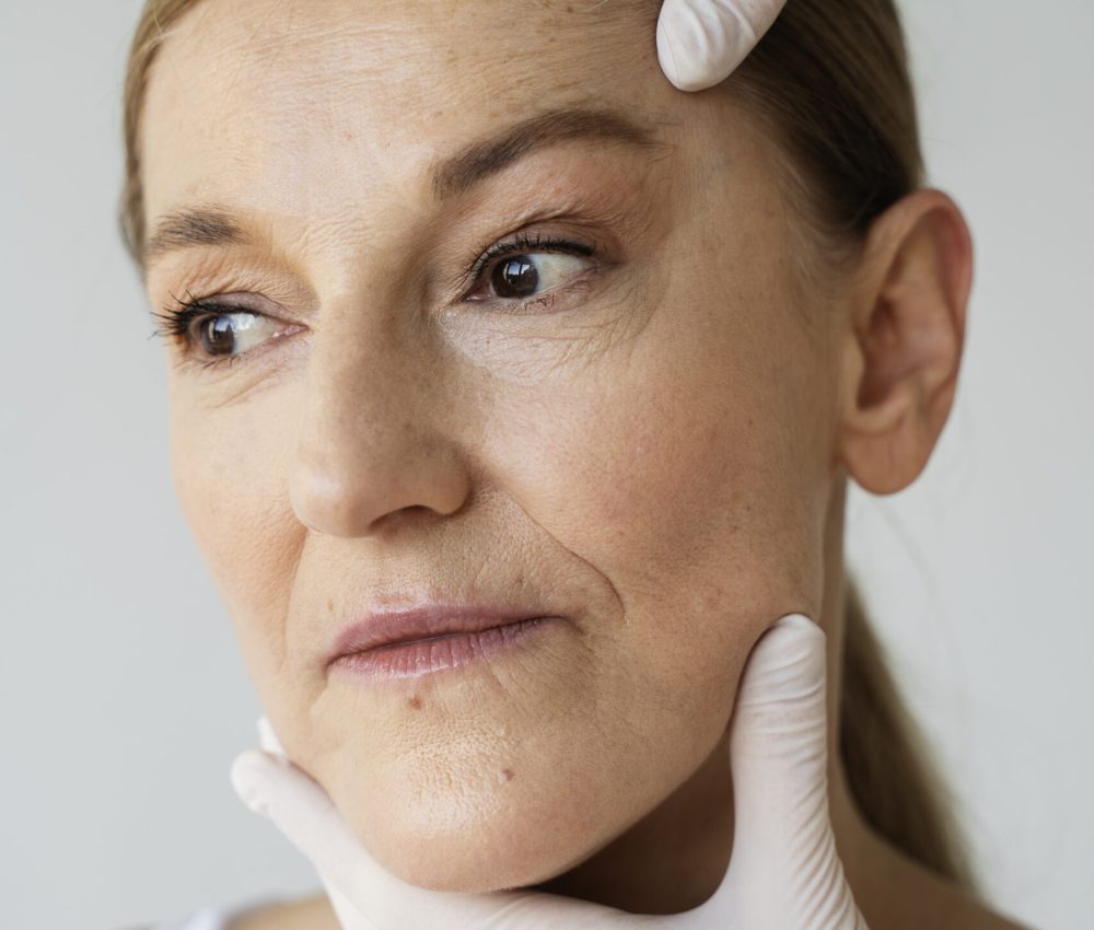 manos-con-guantes-tenencia-mujer-cara