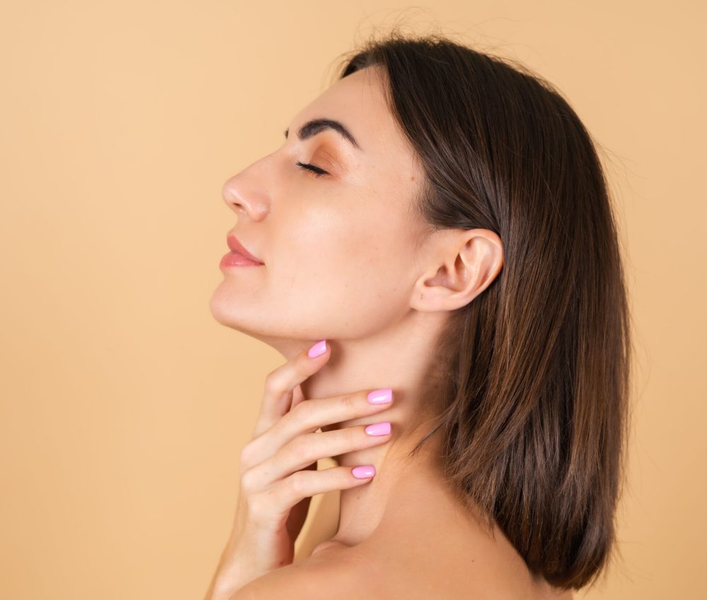 Portrait of a young girl on a beige background with natural makeup, with a light sensual smile, bare shoulders, beauty face, advertising of cosmetics and care